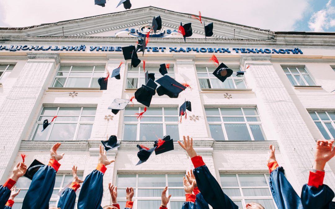 phd graduates in academia for a job in the private sector throw their caps in the air at graduation